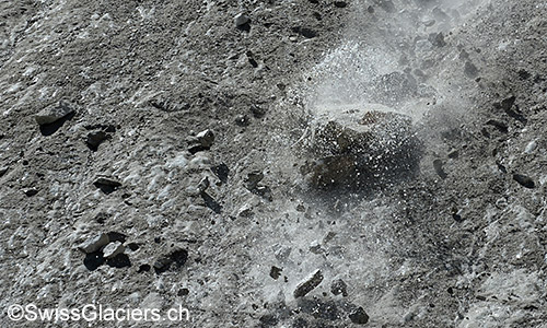 Grosser Felsblock rutscht von der Kante der Toteisfront in die Tiefe.