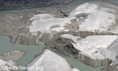 Rhonegletscher: Mit Sand bedecktes Gletschereis im proglazialen See am 29.7.2024, Detail.
